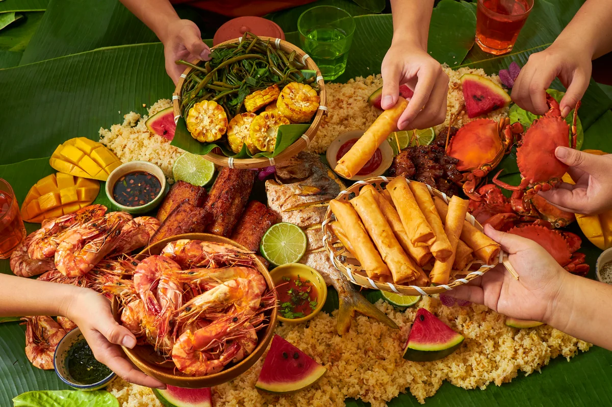 A spread of Filipino food shared by hand on banana leaves