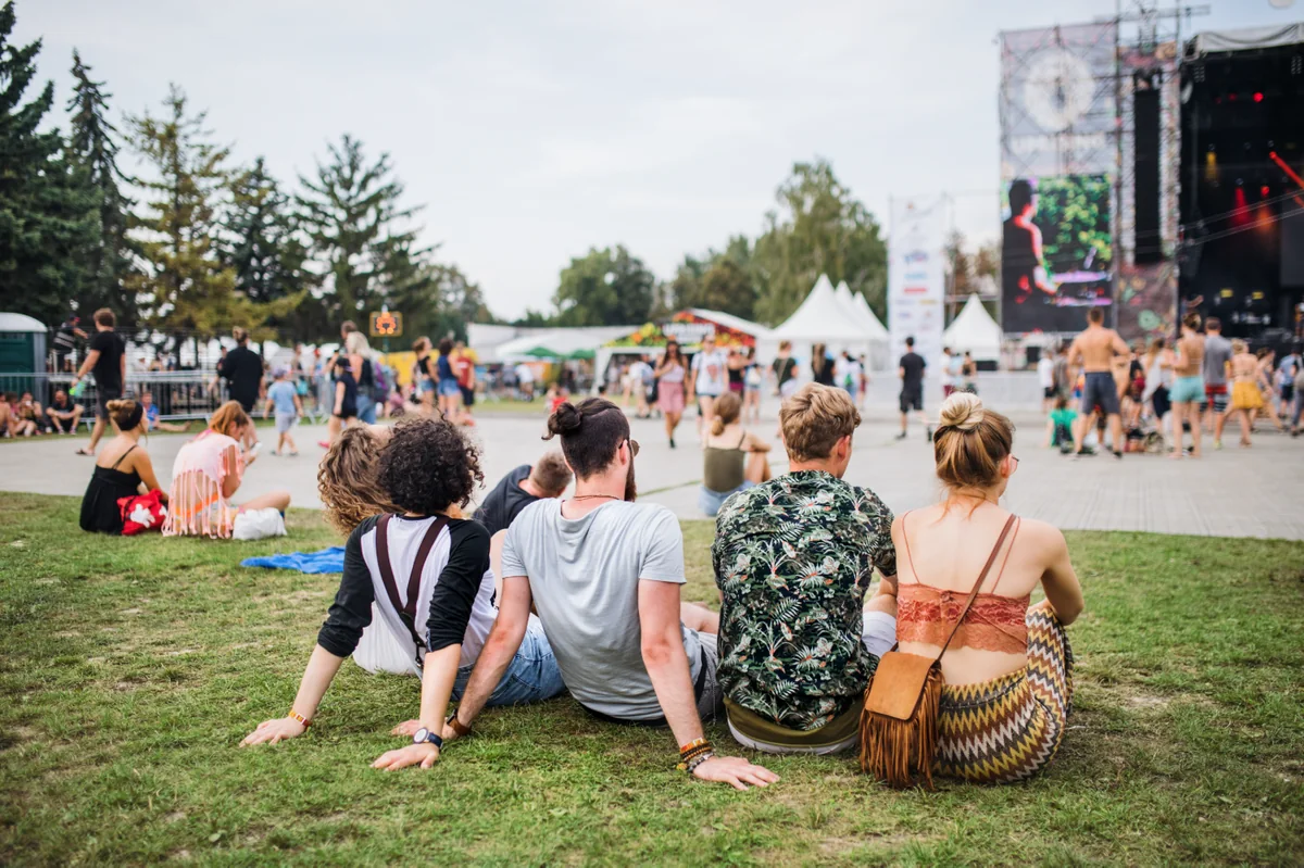 Friends relaxing on the grass in front of a festival stage